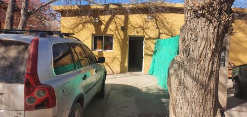 a car parked next to a tree in front of a house at Casa en uspallata in Uspallata