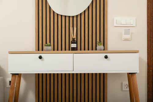 a white dresser with a mirror on a wall at Ekati Seaside Living in Kolymvari