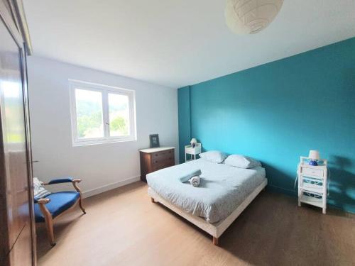 - une chambre avec des murs bleus, un lit et une chaise dans l'établissement La Maison des Noyers #Parking#Calme#Terrasse, à Ceyrat