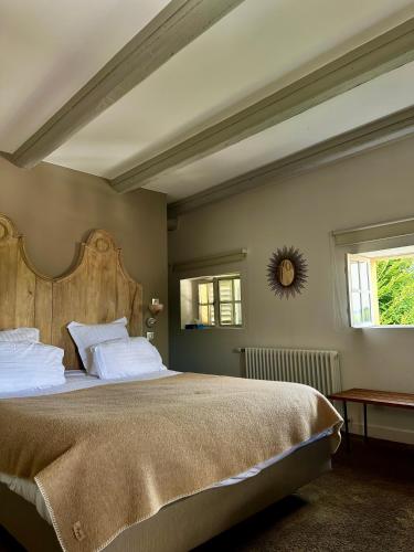 une chambre avec un grand lit avec une tête de lit en bois dans l'établissement Le Clos Jeannon, à Nancy
