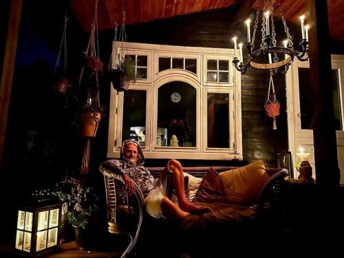 a man sitting on a couch in a living room at Rågeleje's Oasis - Coastal Home with Wood Burning Sauna in Græsted