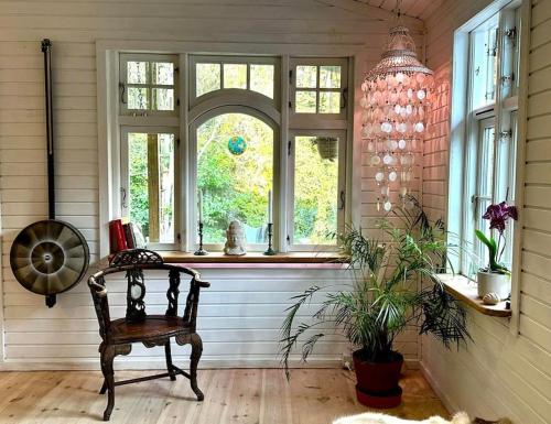 a room with a chair and a window at Rågeleje's Oasis - Coastal Home with Wood Burning Sauna in Græsted