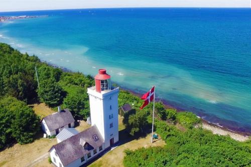 an aerial view of a lighthouse next to the ocean at Rågeleje's Oasis - Coastal Home with Wood Burning Sauna in Græsted