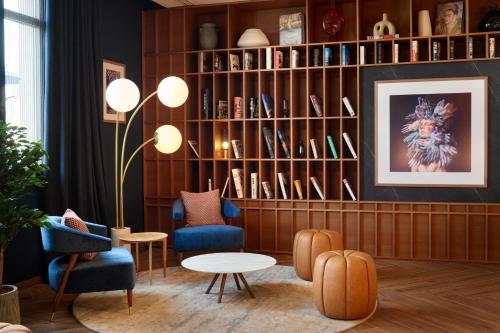a living room with chairs and a book shelf at Radisson Blu Hotel Marseille Vieux Port in Marseille