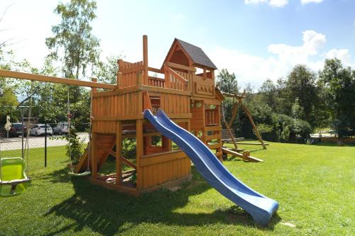 a wooden play structure with a slide and a playground at Pod Hawraniem Ski & Bike Friendly in Jurgów
