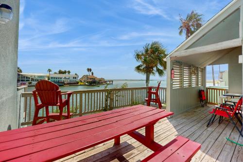 a red bench on a deck with a view of the water at Puente Vista in Corpus Christi