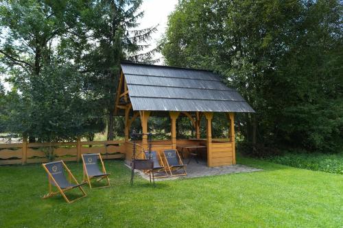 a gazebo with chairs and a table in the grass at Pod Hawraniem Ski & Bike Friendly in Jurgów