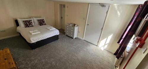 a bedroom with a bed and a dresser in a room at Plas Bellin Studios in Mold