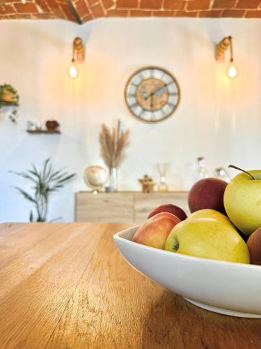 a bowl of apples on a wooden table with a clock at Bricks House in Chieri