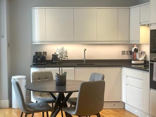 a kitchen with a table and chairs in a kitchen at The Cadogan Suite by Harrods in London
