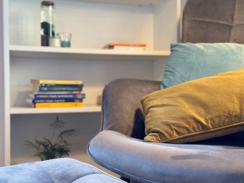 a couch with a pillow and books on a shelf at Bricks House in Chieri