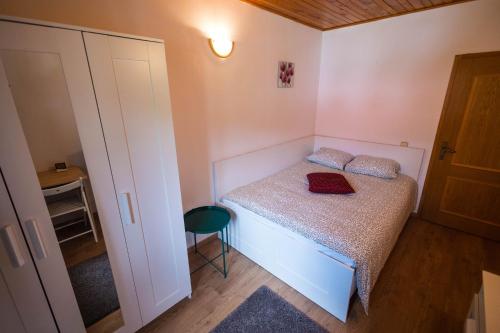 a small bedroom with a bed and a stool at Cuibul Zăganului - Relax, Sauna & SPA in Cheia