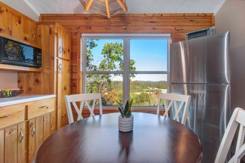 Una cocina con una mesa y un refrigerador de acero inoxidable. en Near Douglas Lake Mountain Jewel Haven with Views, en Sevierville