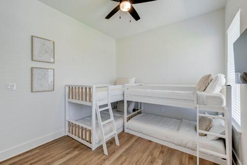 a room with two bunk beds and a ceiling fan at Salt & Stone Villas in Galveston