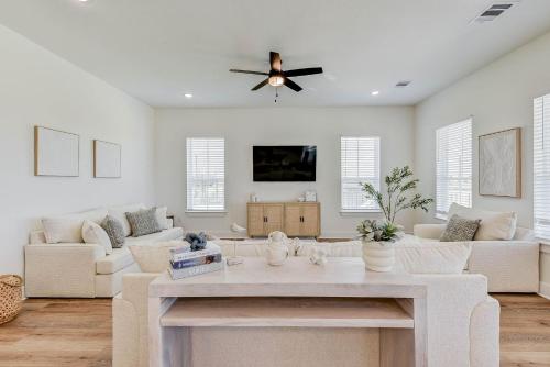 a living room with white furniture and a ceiling fan at Salt & Stone Villas in Galveston