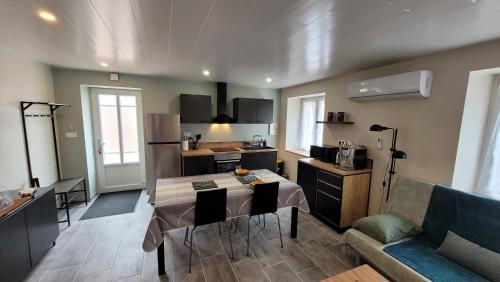 une cuisine et un salon avec une table et un canapé dans l'établissement La Petite Fonderie, à Luxeuil-les-Bains