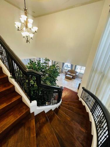 a staircase in a house with a chandelier at Elle Casa is a modern-European inspired house coc in San Pablo