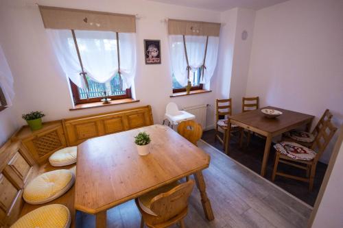 a dining room with a wooden table and chairs at Cuibul Zăganului - Relax, Sauna & SPA in Cheia