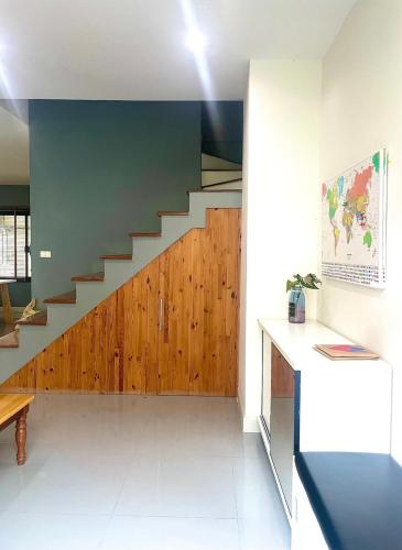 a living room with a staircase with wooden panels at Stay like a local in Modern Townhome in Ban Non Muang