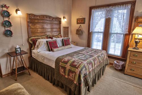 a bedroom with a bed with a wooden headboard and a window at Rockwell Falls Inn and Wine Bar in Lake Luzerne