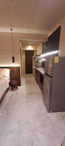 a room with a bed and a kitchen with a refrigerator at MID-498 Centro in Mérida