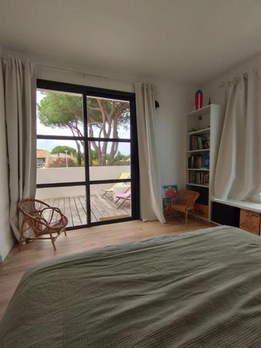 une chambre avec un lit et une porte coulissante en verre dans l'établissement Villa Golf LGM, à La Grande Motte