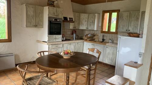 une cuisine avec une table avec un bol de fruits dessus dans l'établissement Maison insolite de mi-montagne, à Pébrac