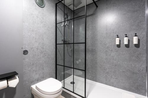 a bathroom with a shower and a toilet at The Bolton Stadium Hotel, a member of Radisson Individuals in Bolton
