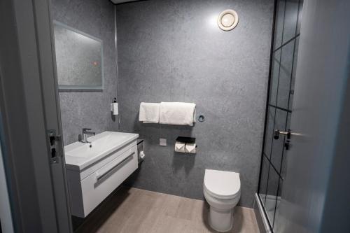 a bathroom with a white toilet and a sink at The Bolton Stadium Hotel, a member of Radisson Individuals in Bolton