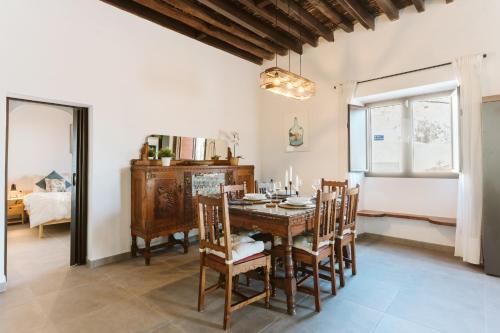 Magec Villa de Arico في Lomo de Arico: غرفة طعام مع طاولة وكراسي خشبية