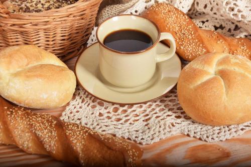 a cup of coffee and bread on a table at Hotel-Pension Waldeck in Todtmoos