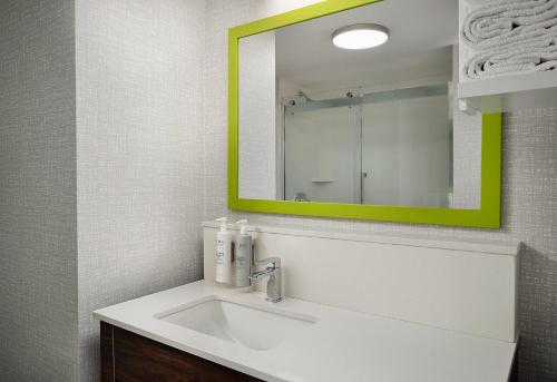 a bathroom with a sink with a green mirror at Hampton Inn San Diego/Del Mar in San Diego