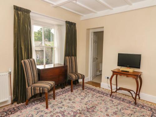 a living room with a piano and chairs and a television at Kearton Shunner Fell in Richmond