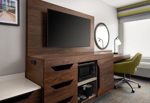 a living room with a television and a chair at Hampton Inn San Diego/Del Mar in San Diego