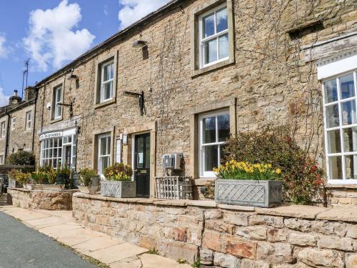 a brick building with windows and potted plants at Keartons - Buttertubs in Richmond