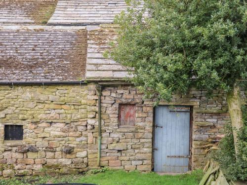 an old stone building with a blue door at Keartons - Buttertubs in Richmond