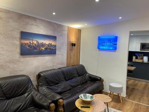 a living room with a leather couch and a table at Ferienwohnung E in Soltau