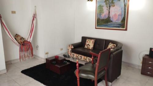 a living room with a couch and a chair at Cerca a Parque Nariño in Pasto