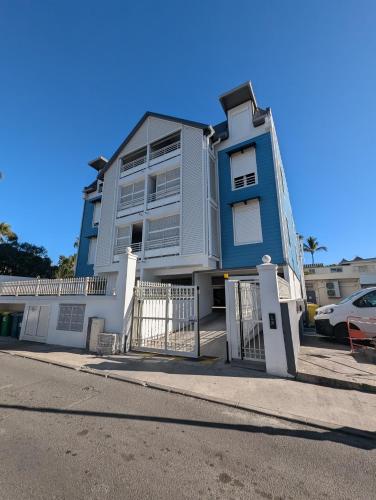 a blue and white house with a fence in front of it at Le Zanlik - Rare, 100m du Lagon, Hypercentre Saint-Leu in Saint-Leu