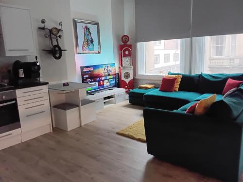 ein Wohnzimmer mit einem blauen Sofa und einem Fernseher in der Unterkunft Queen Street Quayside Apartment, NE1 Grade 2 Listed in Newcastle upon Tyne