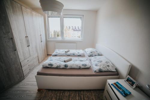 a small bedroom with a bed and a window at Apartmán Tatranská Lomnica in Tatranská Lomnica