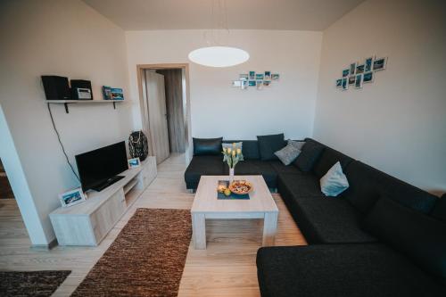 a living room with a black couch and a table at Apartmán Tatranská Lomnica in Tatranská Lomnica