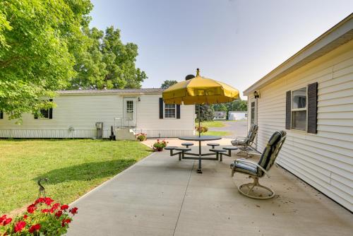 a patio with a table and a yellow umbrella at Cozy Lakemont Getaway, 11 Mi to Watkins Glen! in Lakemont