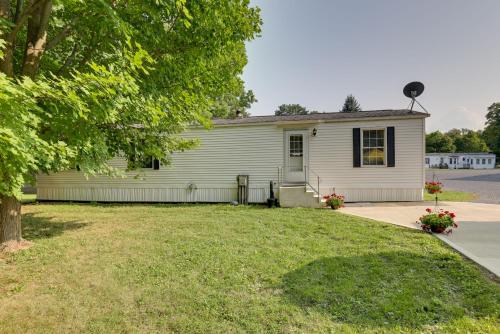 a white house with a tree and a yard at Cozy Lakemont Getaway, 11 Mi to Watkins Glen! in Lakemont