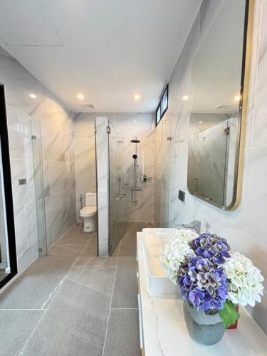 a bathroom with a vase of flowers on a counter at Gaia Pool Villa Khao Yai in Ban Bung Toei