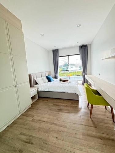 a bedroom with a bed and a large window at Gaia Pool Villa Khao Yai in Ban Bung Toei