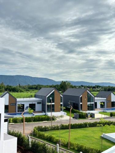 a row of houses in a park with a yard at Gaia Pool Villa Khao Yai in Ban Bung Toei