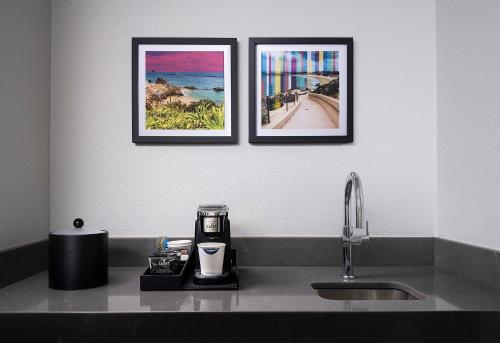 two framed pictures on a wall above a kitchen sink at Hampton Inn San Diego/Del Mar in San Diego