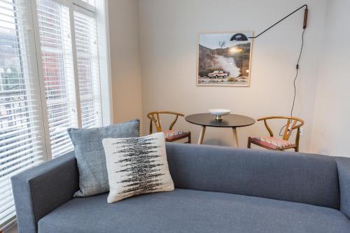 a blue couch in a living room with a table at Mint House Nashville - Hillsboro Village in Nashville