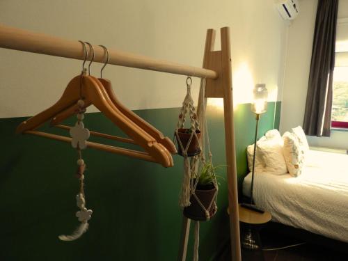 a bedroom with a bed and a wooden bed frame with hangers at Guesthouse De Wissen in Dilsen-Stokkem